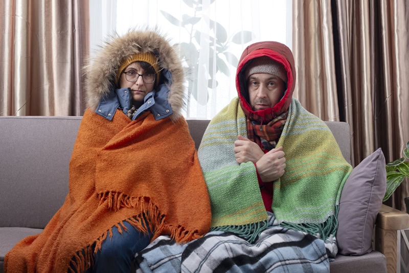 Family freezing in living room from spotty heating.